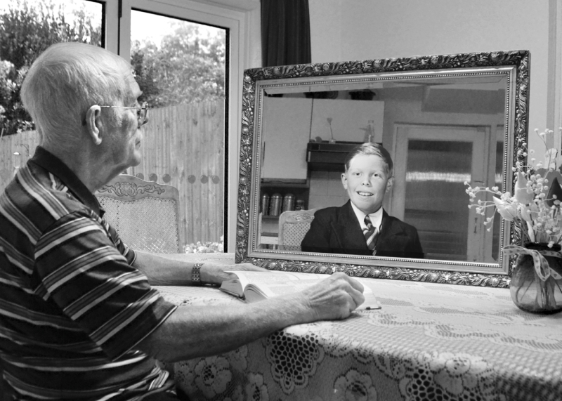 A person with a picture of their younger self